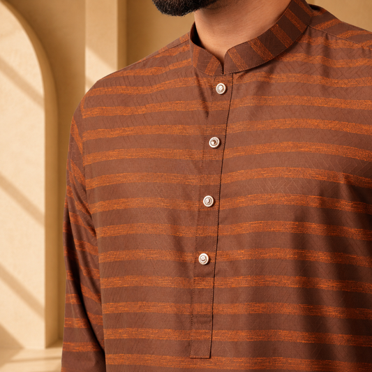 Brown and orange striped yamaan royal panjabi worn by a person against a beige wall.