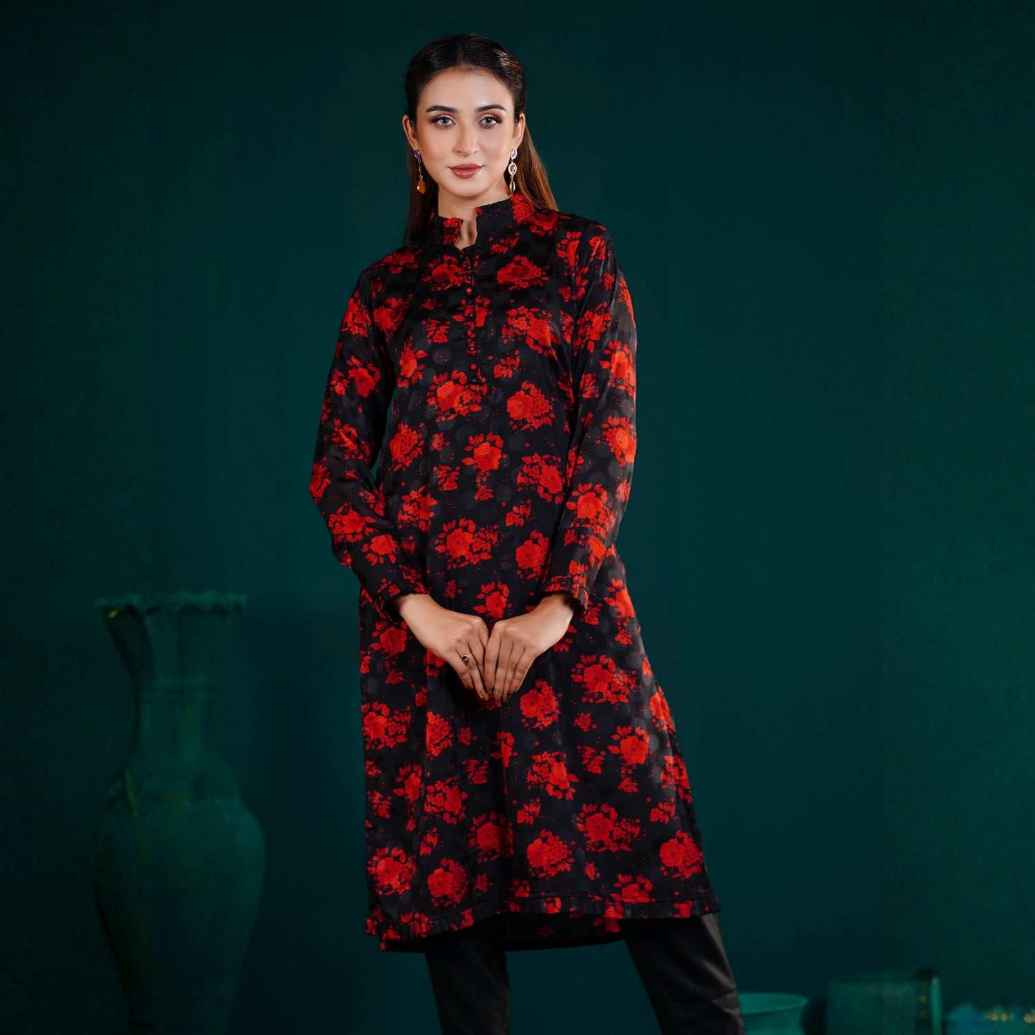 Woman wearing a yamaan royal black kurti with red floral pattern against a dark green background