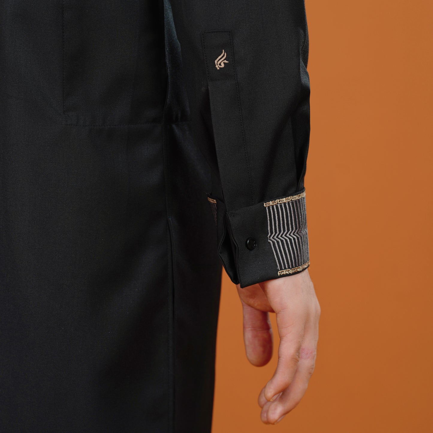 Black coat with gold accents on an orange background