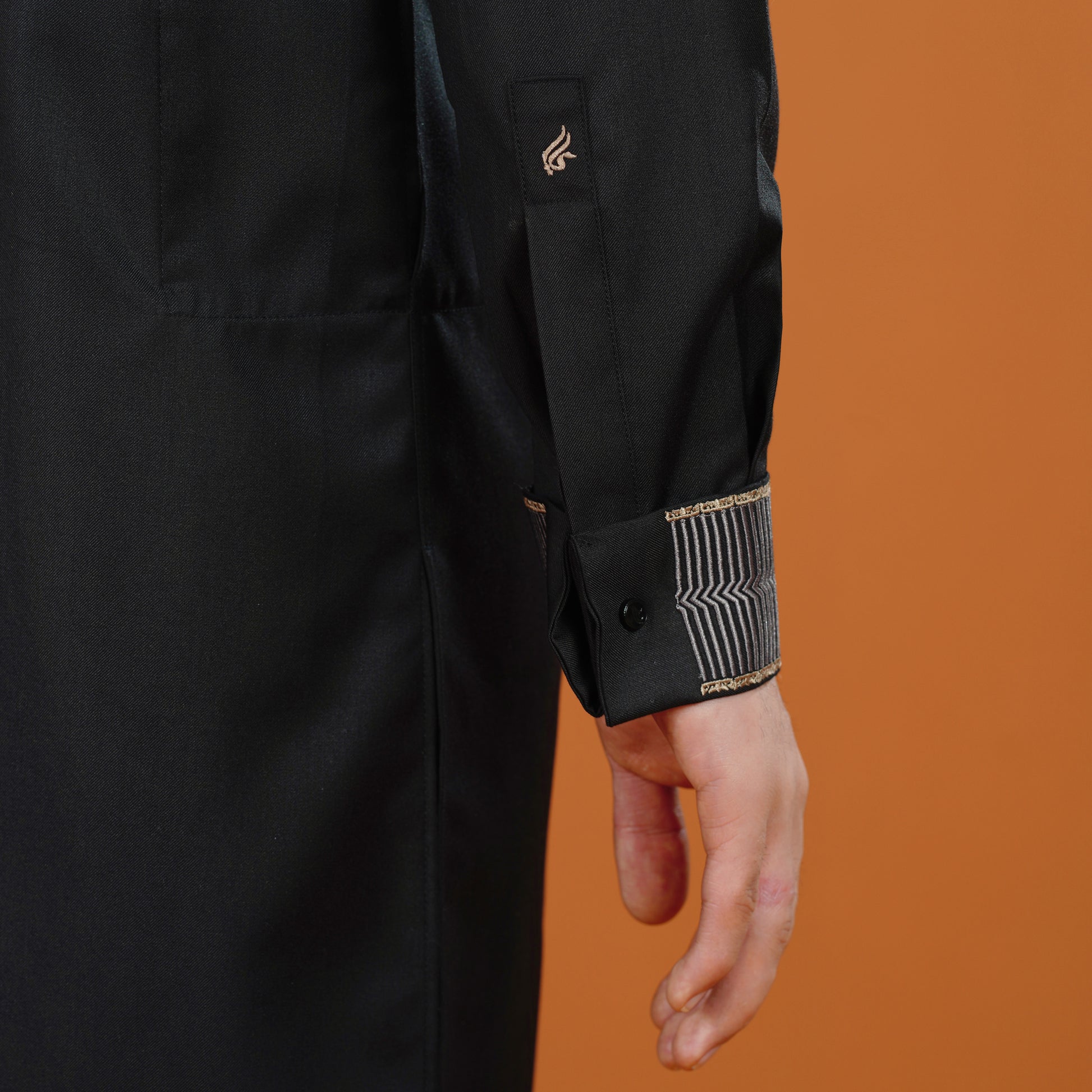 Black coat with gold accents on an orange background