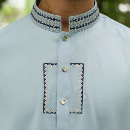 Light blue kurta with embroidered details on a blurred natural background