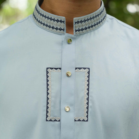 Light blue kurta with embroidered details on a blurred natural background