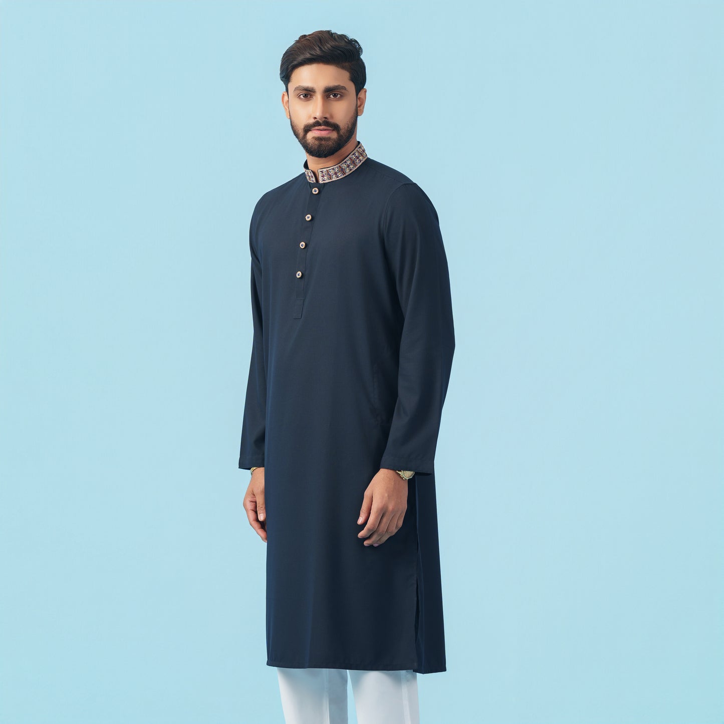 Man wearing a dark blue kurta with a light blue background
