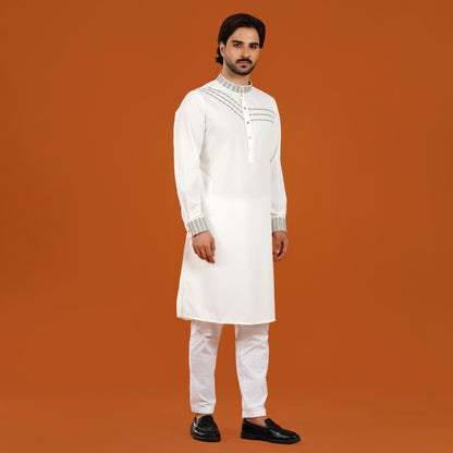 Man wearing a white kurta with embroidery on an orange background