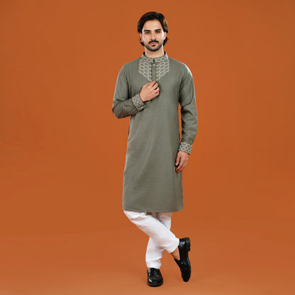 Man wearing a green kurta with white pants on an orange background