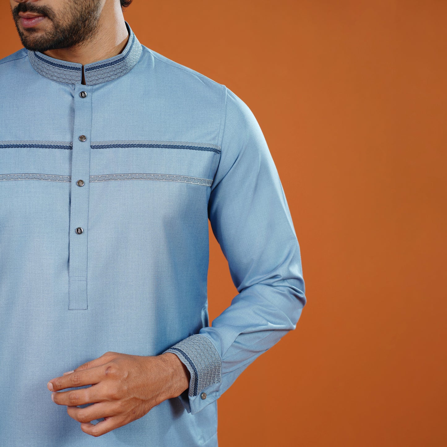 YAMAAN Light blue long-sleeve shirt with button details on an orange background