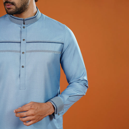YAMAAN Light blue long-sleeve shirt with button details on an orange background