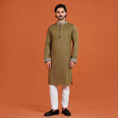 Man wearing a YAMAAN OLIVE kurta with white pants on an orange background