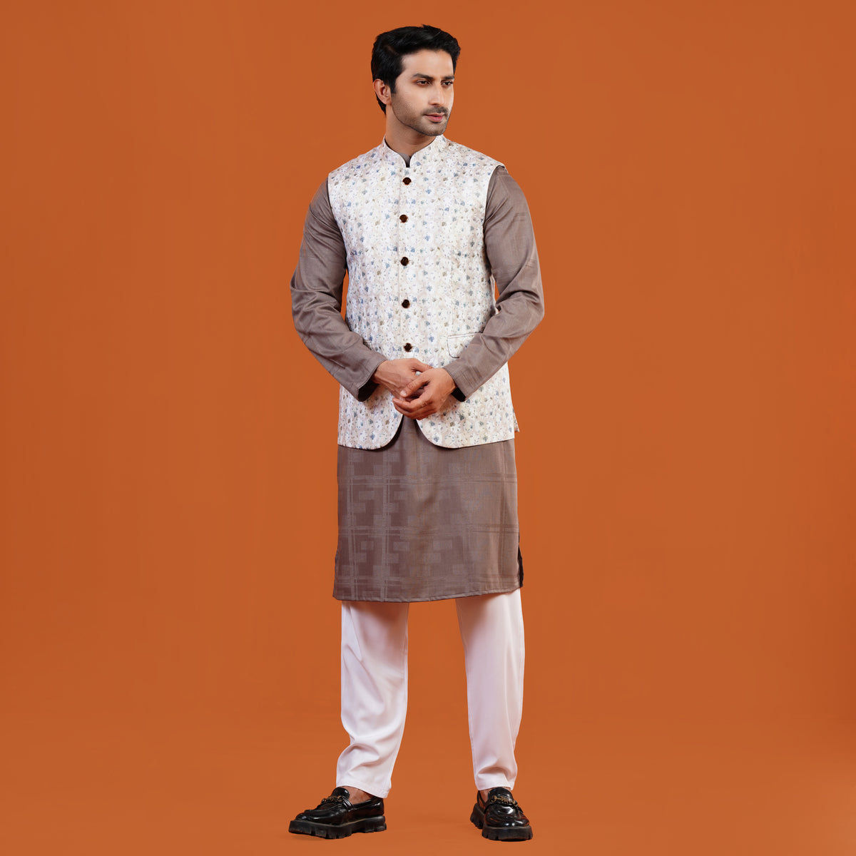 Man wearing a traditional YAMAAN PANJABI with a YAMAAN WAISTCOAT on an orange background