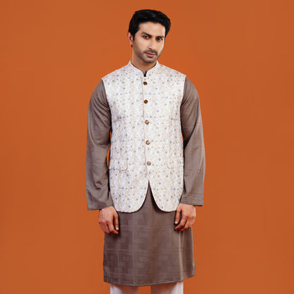 Man wearing a traditional outfit with a patterned vest on an orange background