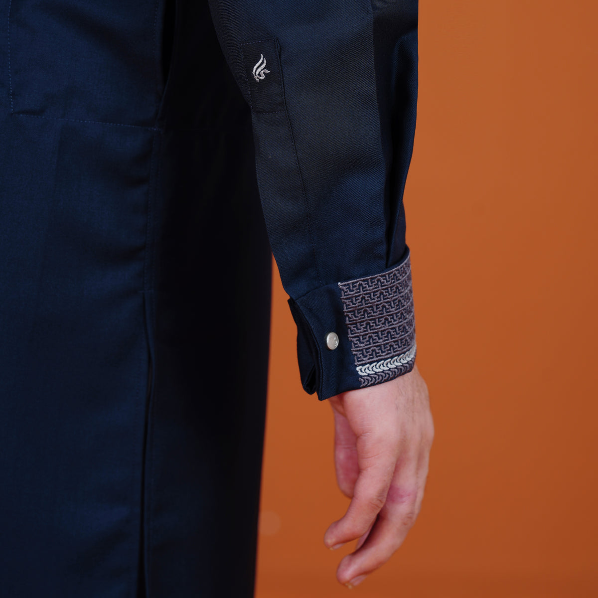 Navy blue shirt with patterned cuff on an orange background