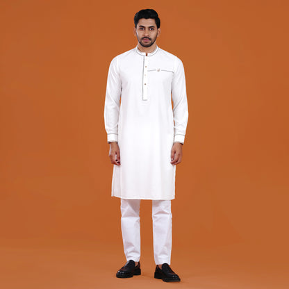 Man wearing a yamaan signature panjabi with black shoes on an orange background