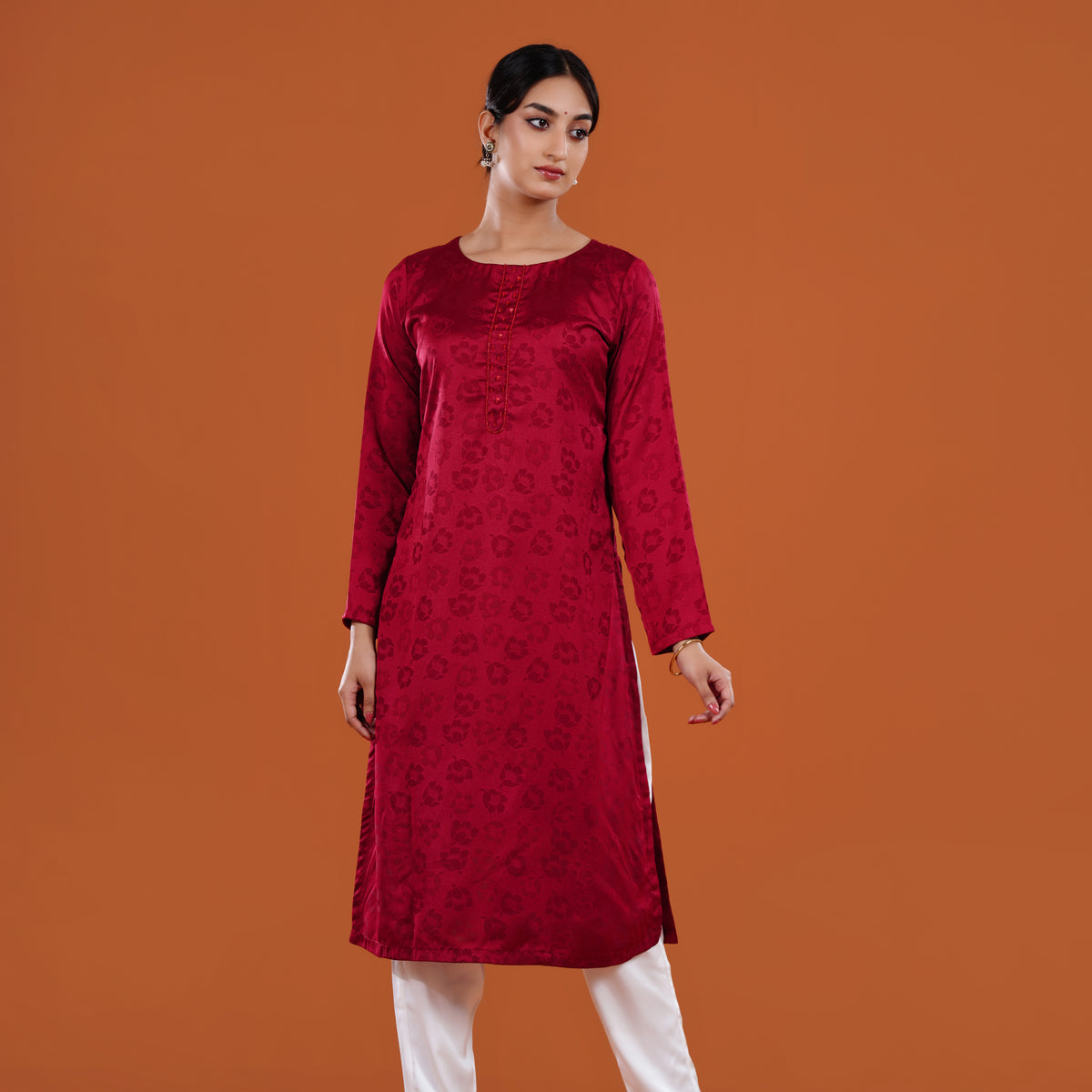 Woman wearing a red patterned kurta against an orange background