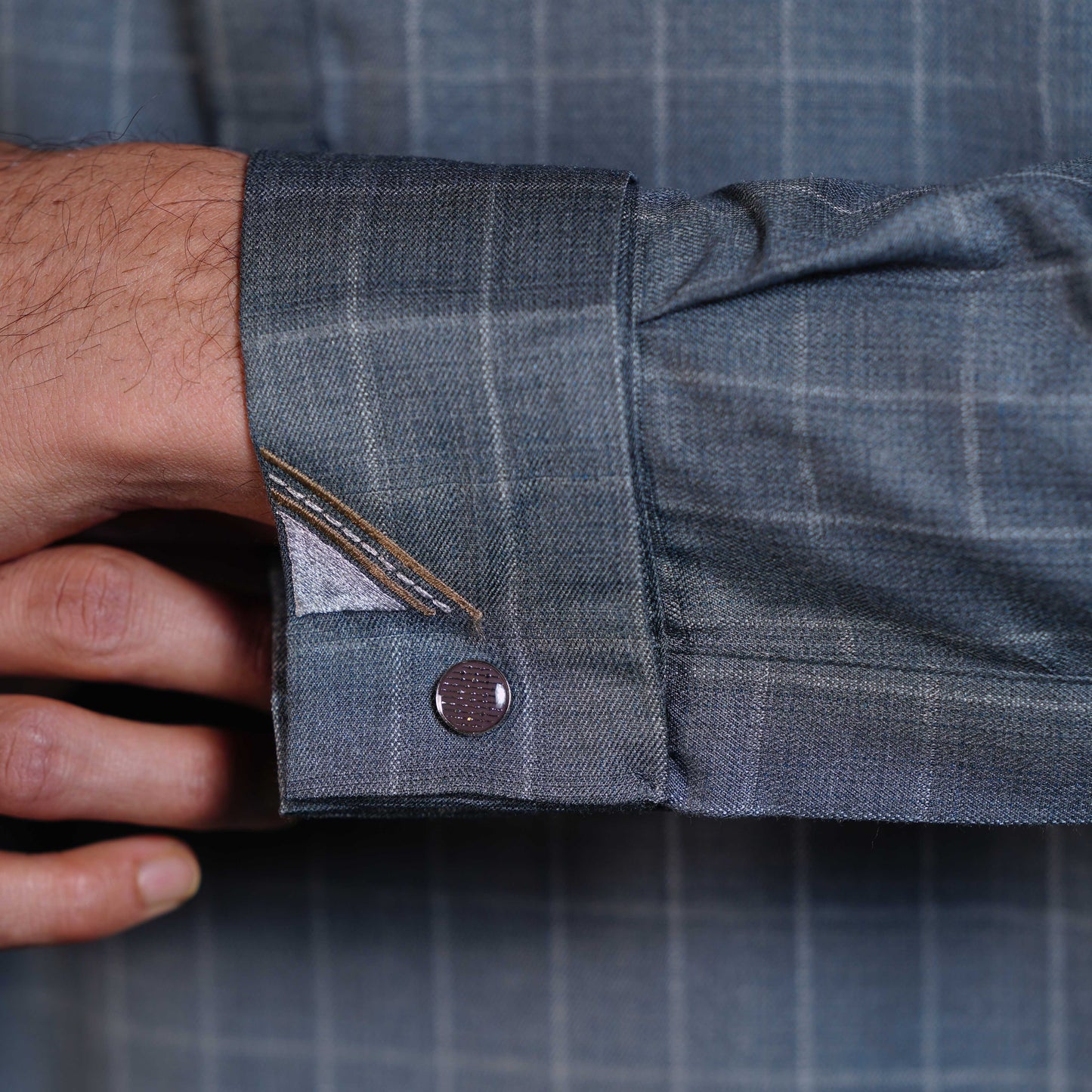 Close-up of a person adjusting the sleeve of a YAMAAN Light Olive Signature Panjabi