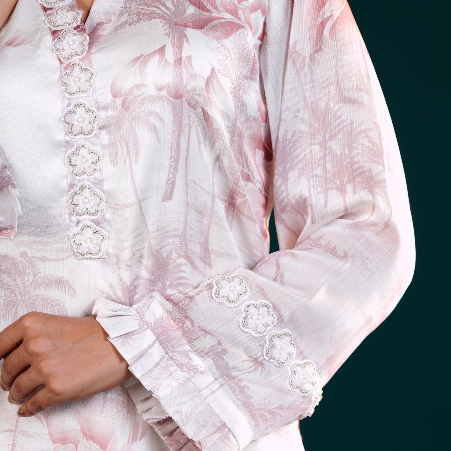 yamaan kurti Close-up of a pink floral dress with white embroidery on a dark background