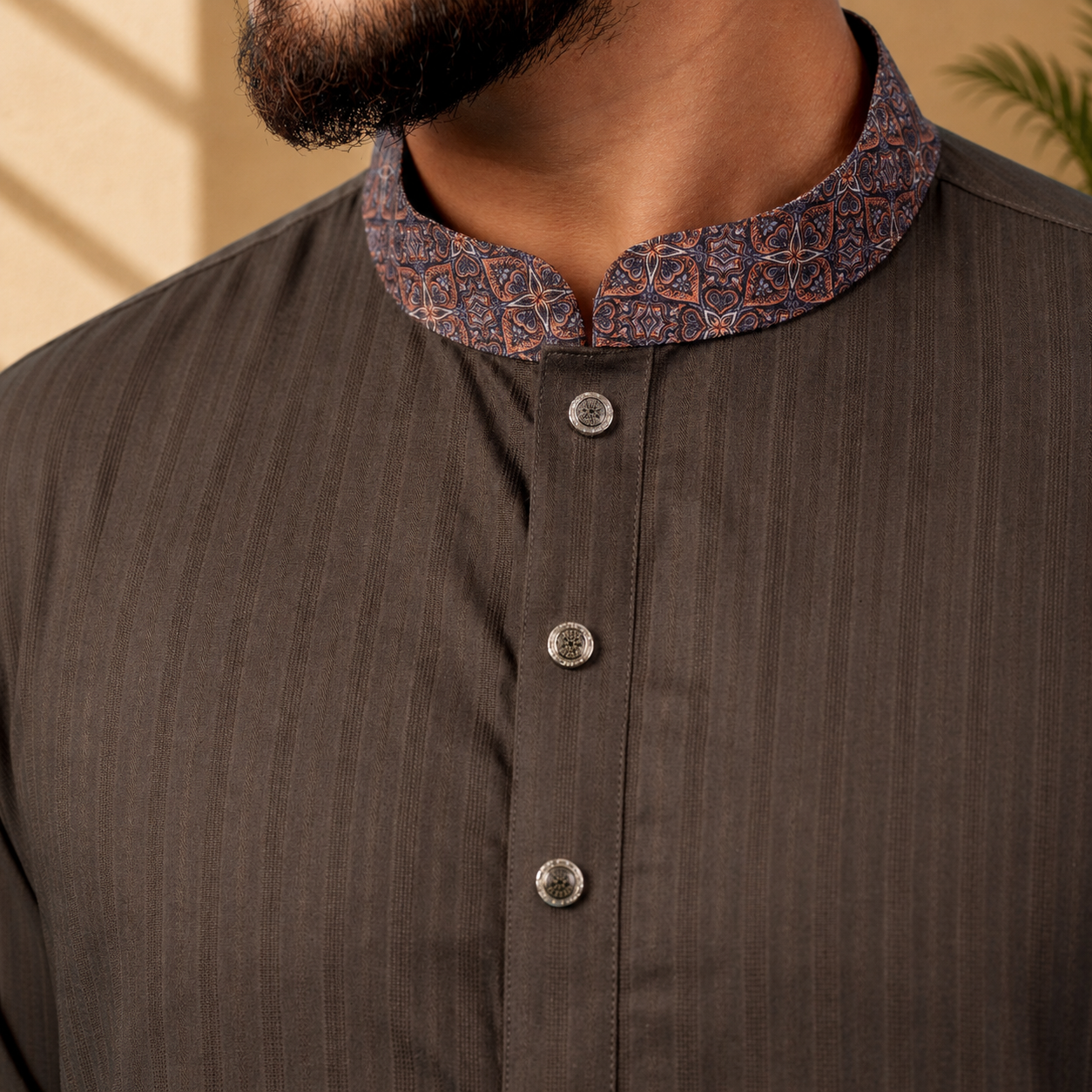 Close-up of a YAMAAN Royal Charcoal Panjabi with a patterned collar against a beige background