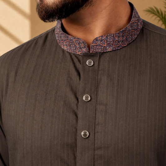 Close-up of a YAMAAN Royal Charcoal Panjabi with a patterned collar against a beige background