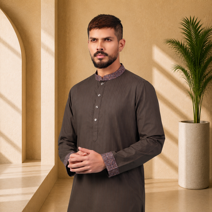 Man wearing a Yamaan Royal panjabi with a patterned collar in a well-lit room with a plant.
