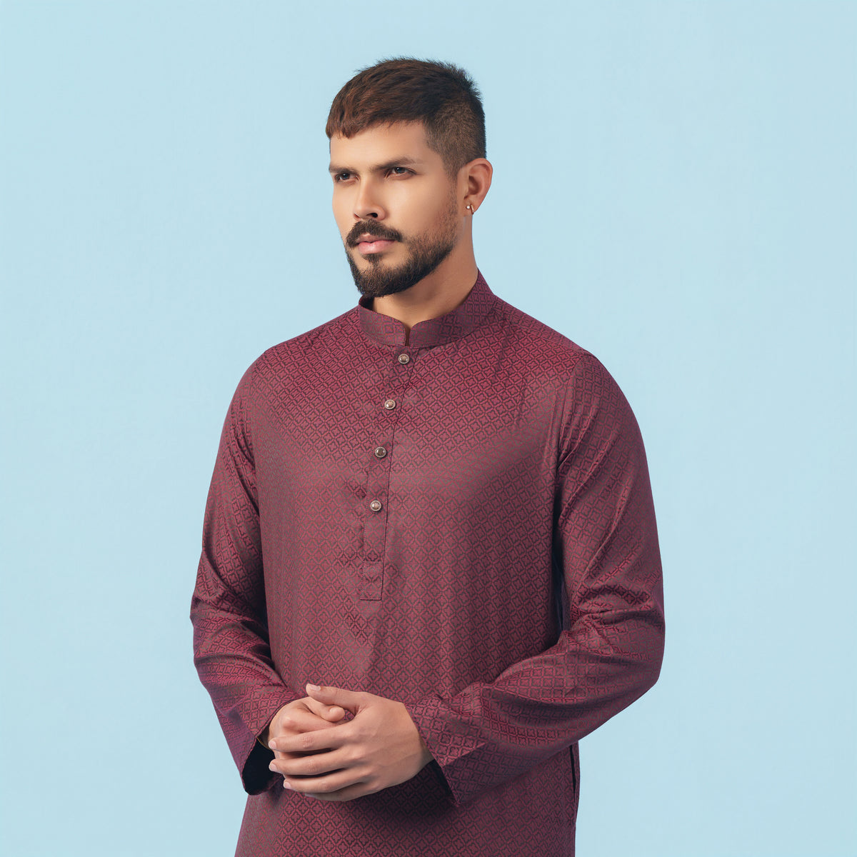 Man wearing a yamaan-royal-panjabi-dark-maroon panjabi against a light blue background