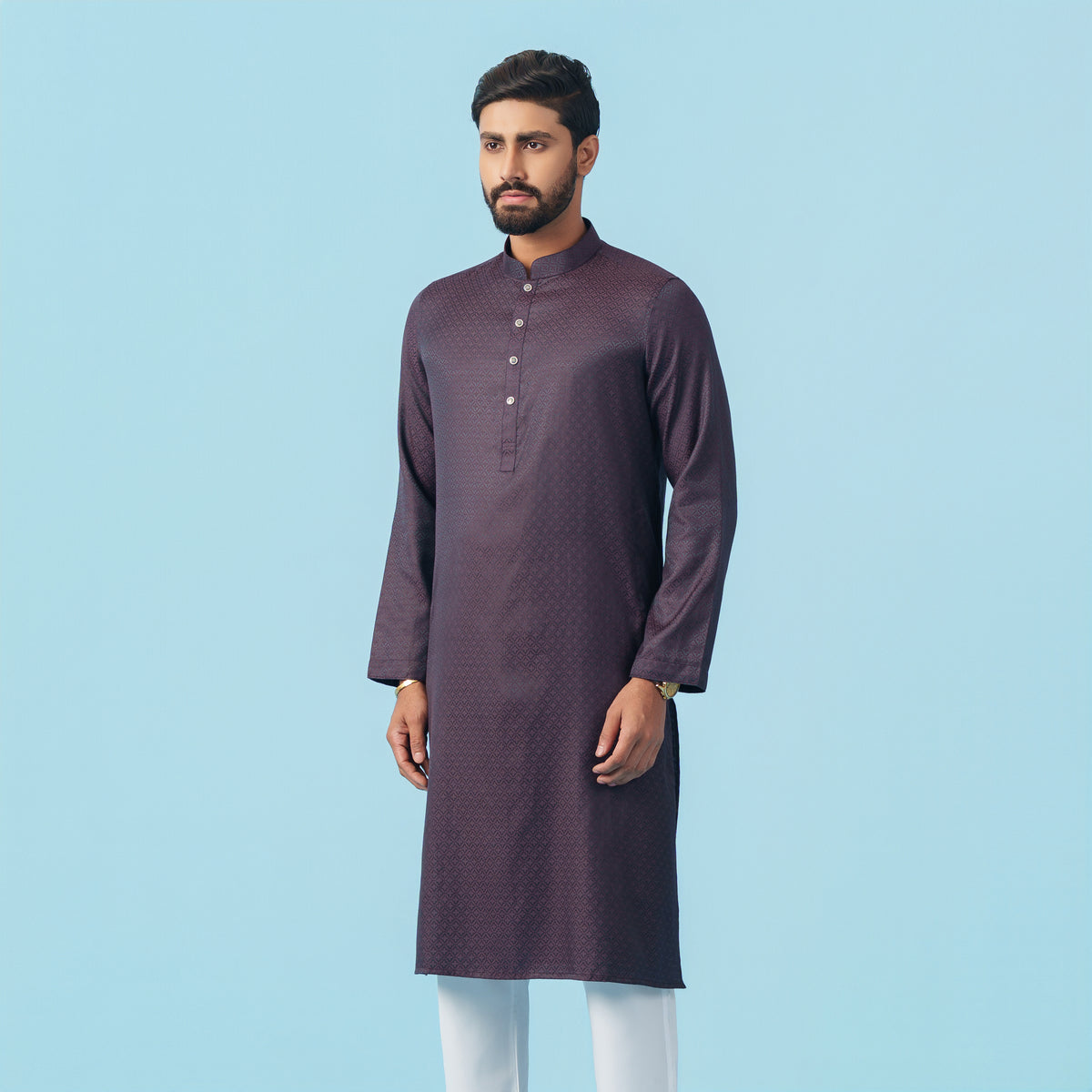 Man wearing a yamaan-royal-panjabi-dark-purple with white pants on a light blue background