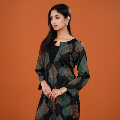 Woman wearing a black and green patterned dress against an orange background