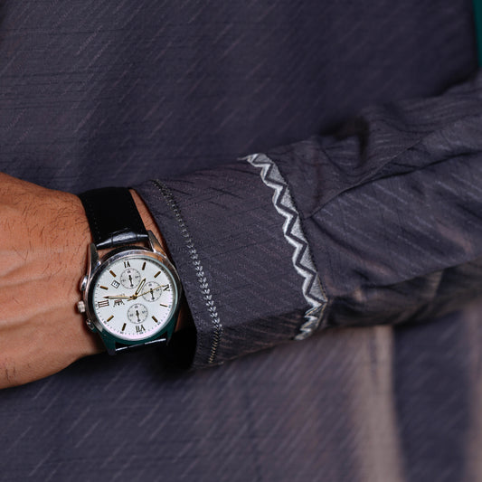 Yamaan grey panjabi close-up of a wrist wearing a watch with a dark shirt sleeve.