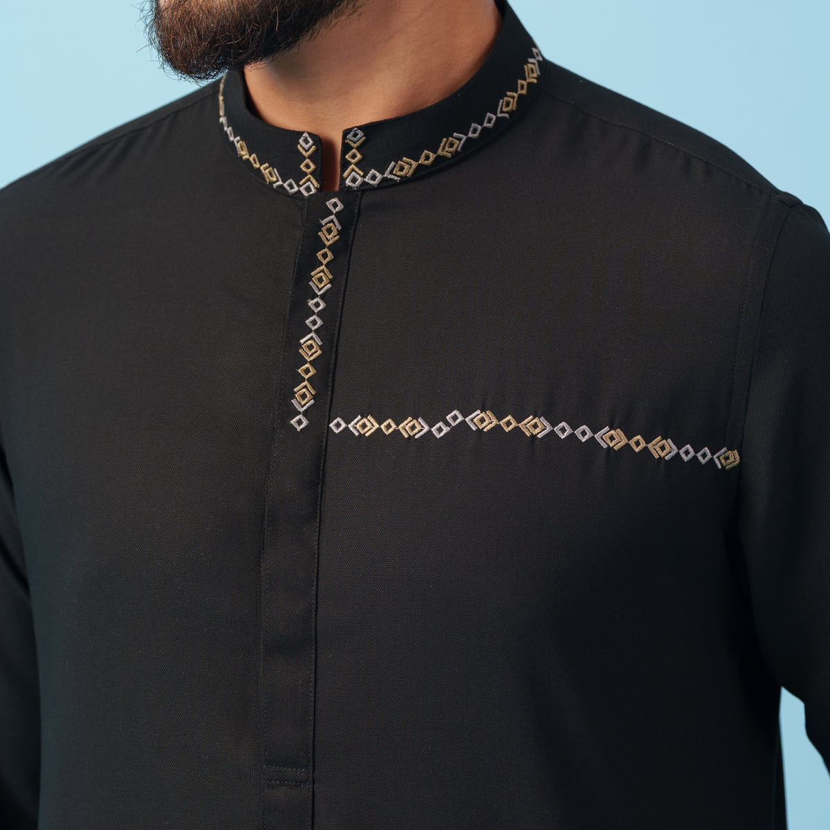 yamaan black panjabi with decorative patterns on a light blue background
