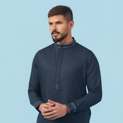 Man wearing a yamaan panjabi with a light blue background