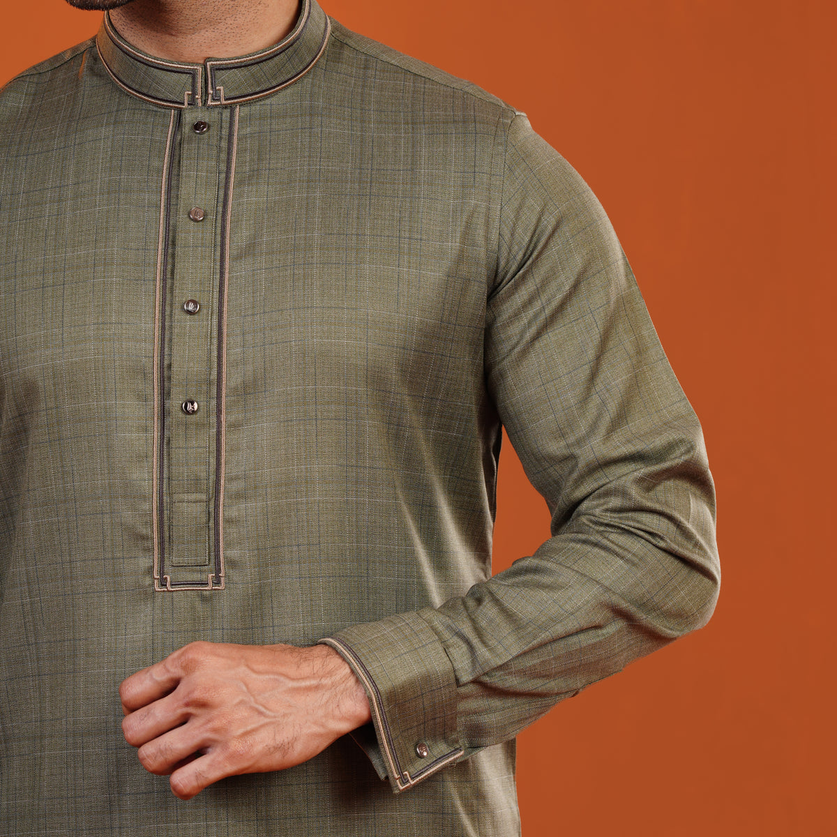 Yamaan traditional panjabi with brown trim on an orange background