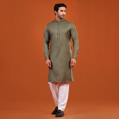 Man wearing a yamaan panjabi with white pants on an orange background