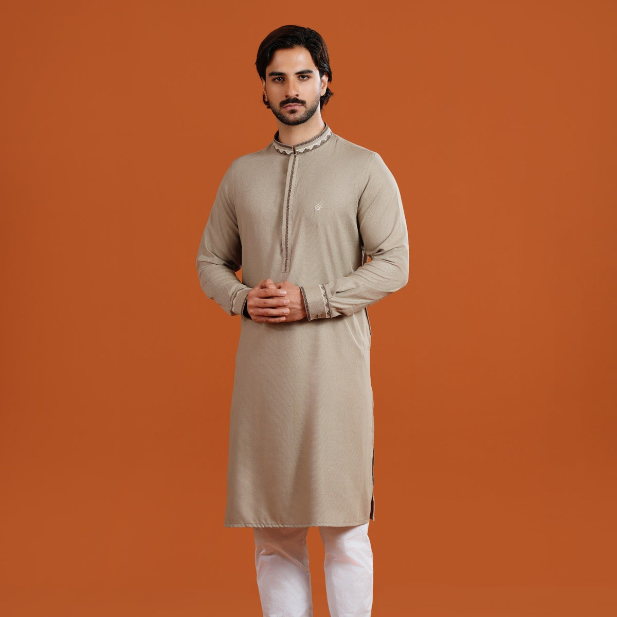 Man wearing a yamaan signature with white pants on an orange background