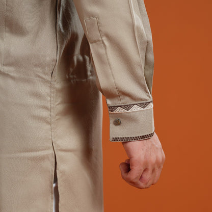 Beige yamaan signature panjabi with embroidered cuffs on an orange background