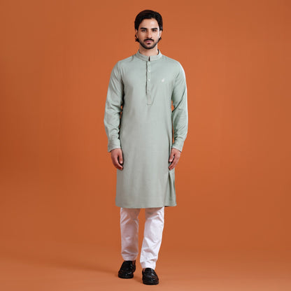 Man wearing a yamaan panjabi with white pants on an orange background