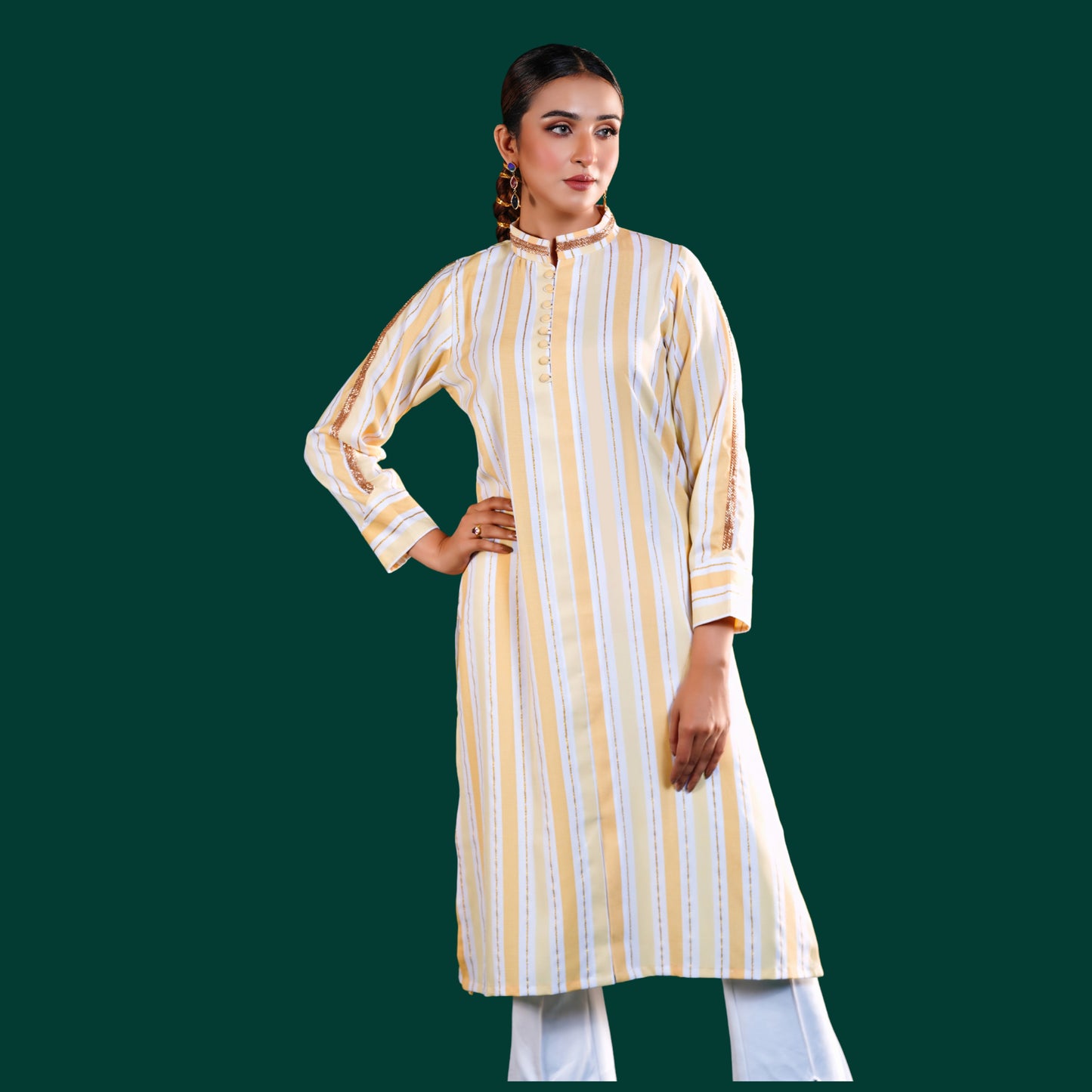 Woman wearing a yellow and white yamaan signature striped kurta with white pants on a green background