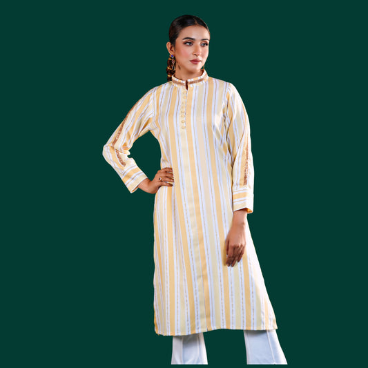 Woman wearing a yellow and white yamaan signature striped kurta with white pants on a green background